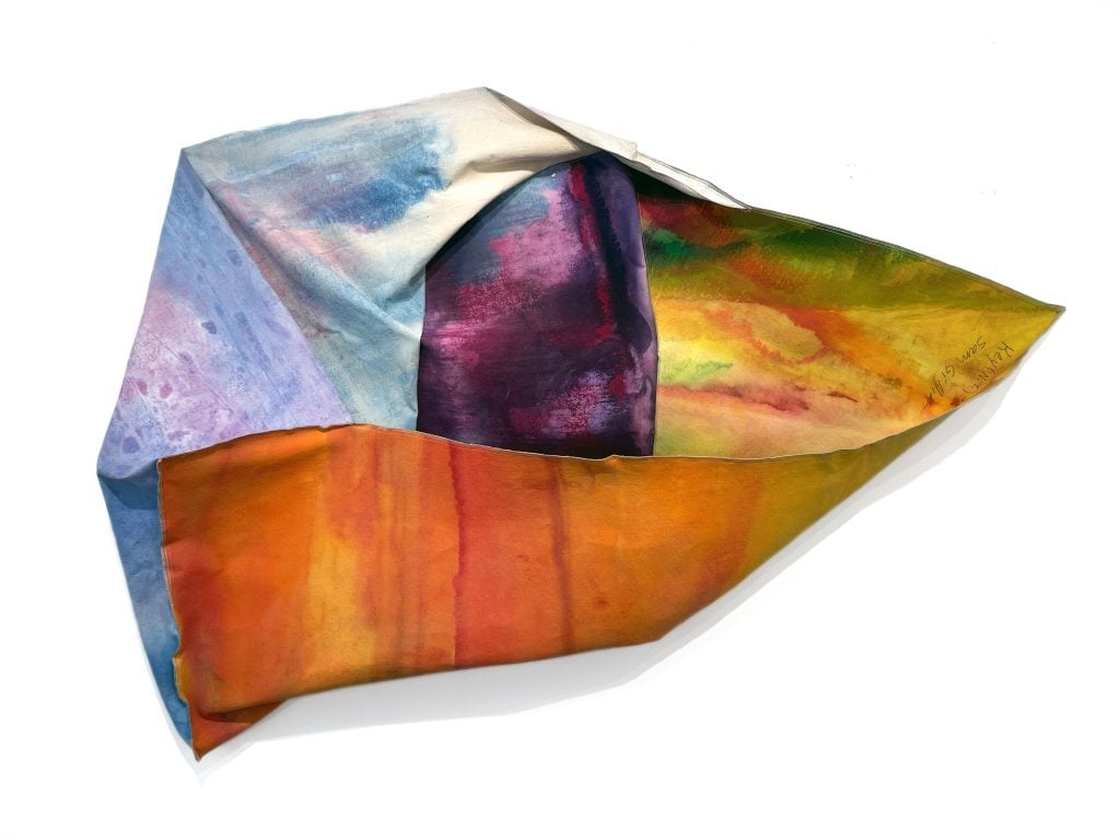 A multicolor canvas that is unstretched and folded in on itself with a corner pointing to the right, featured in Artnet Auctions' GEMS collecting abstract art sale.