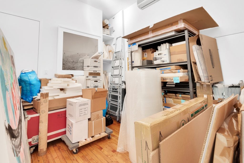 A photograph of a white walled storage room in the apartment of John Tancock and Christophe W. Mao.