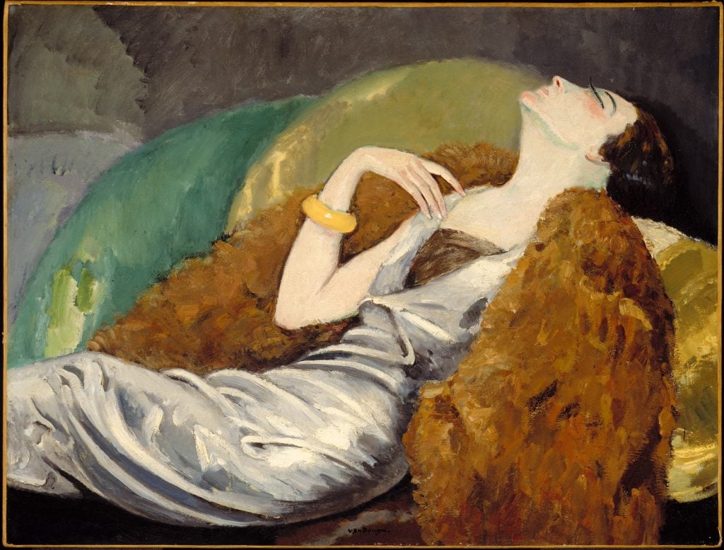 a woman reclining languidly on a soda in a fur stole 