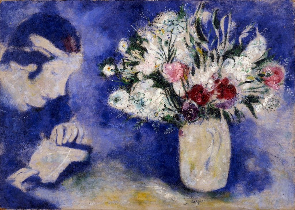 a soft and airy painting of a white, pink, and red flowers in a white vase with a gauzy ultramarine background. to the left of the painting there is a profile of a woman