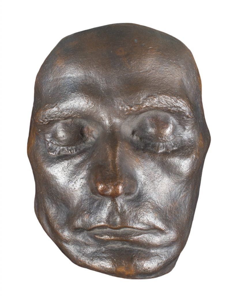 the bronze mask of Egon Schiele on a white background