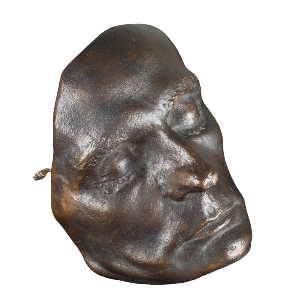 the bronze mask of Egon Schiele on a white background