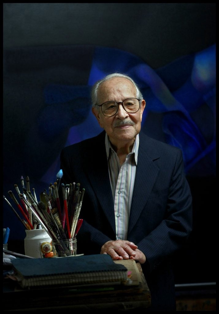 A color photograph of Rafael Soriano at age 91, in 2011, with his paintbrushes..