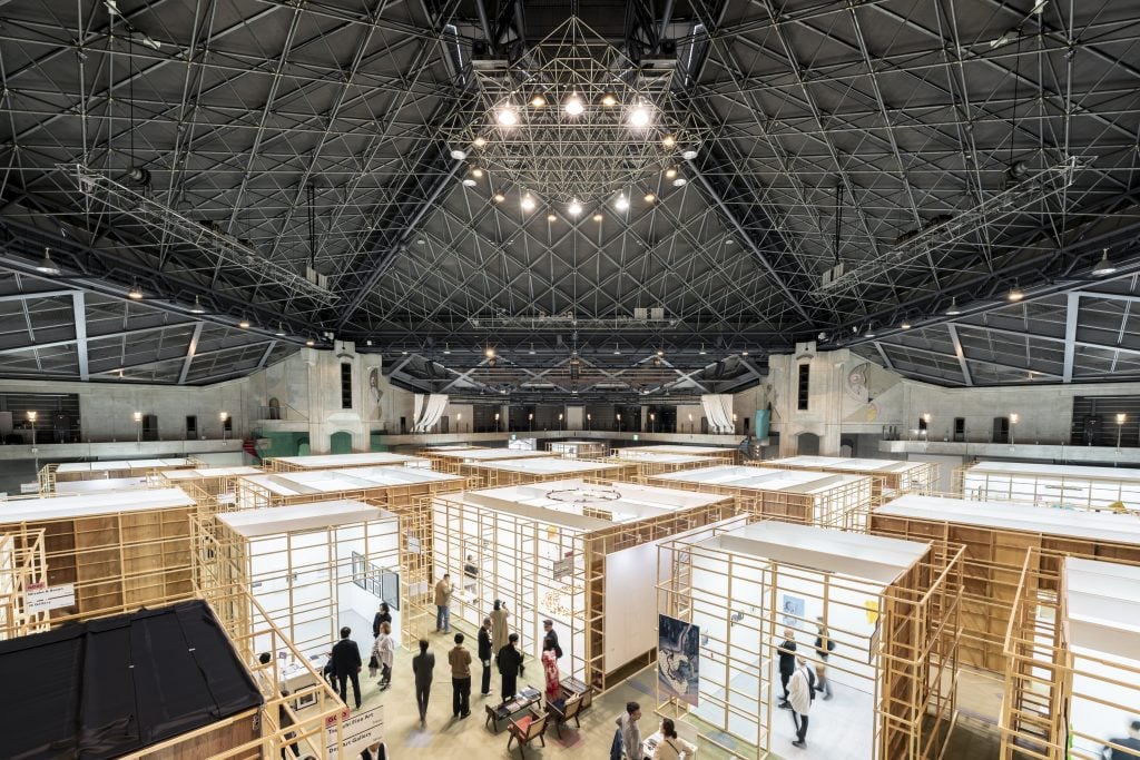 A number wooden booths in a big exhibition hall