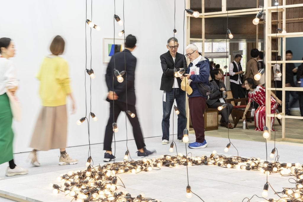 People looking at artworks, an installation of lightbulbs