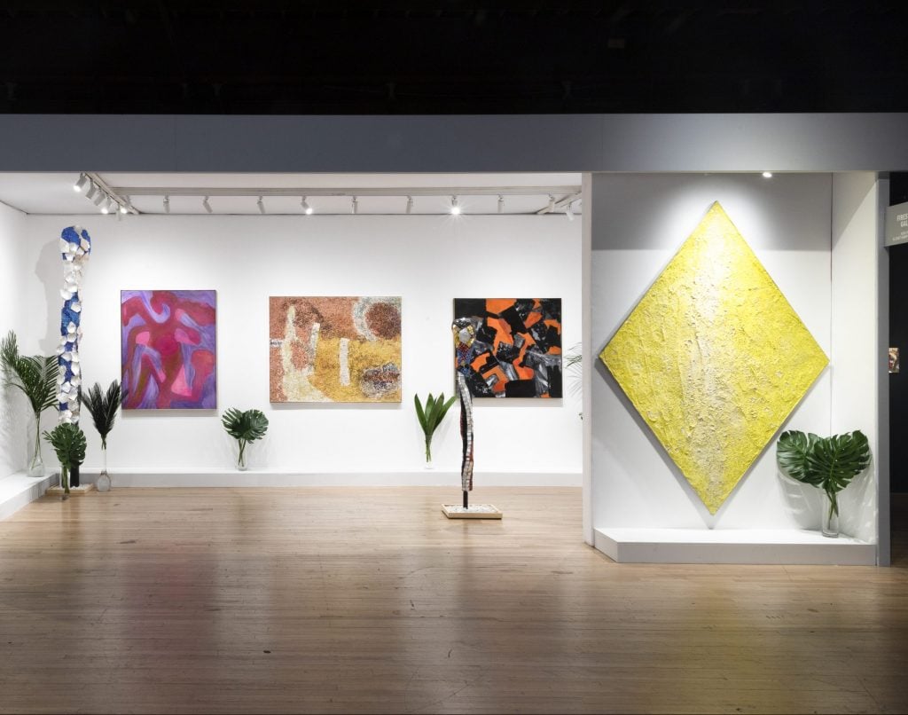 an interior view of an art fair booth filled with abstract art 