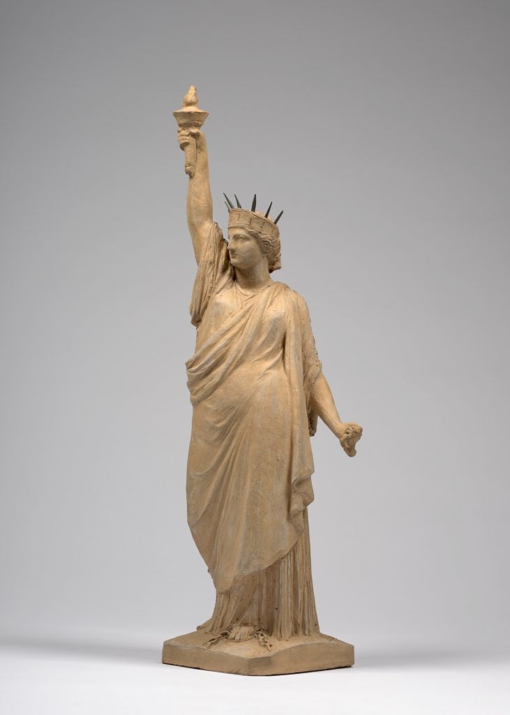 Small-scale terracotta model of the Statue of Liberty by Bartholdi, facing slightly left.