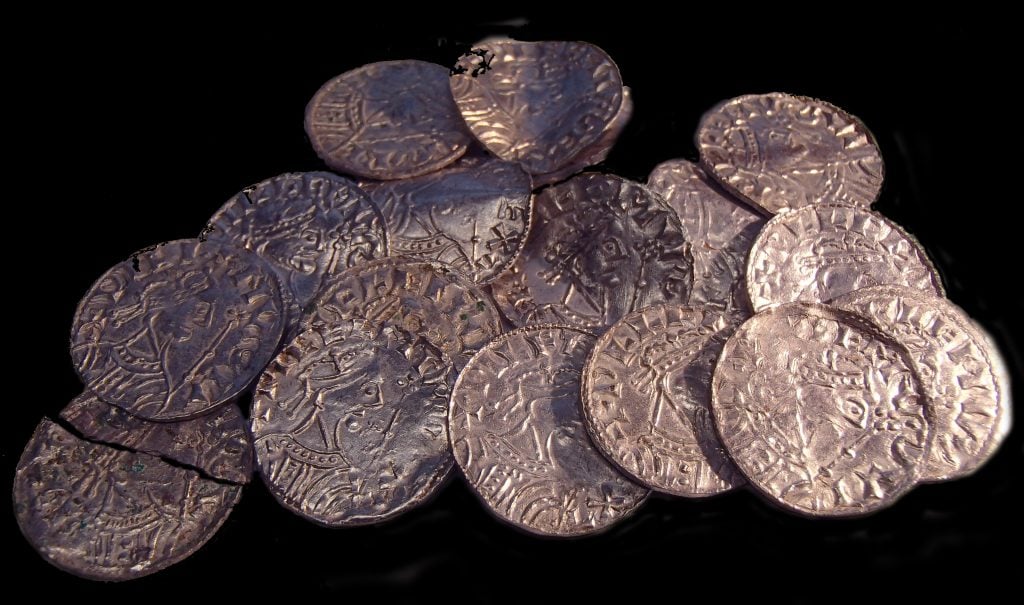 A group of ancient coins sitting on a black surface