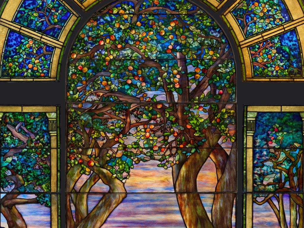 a stained glass window showing trees laden with fruit