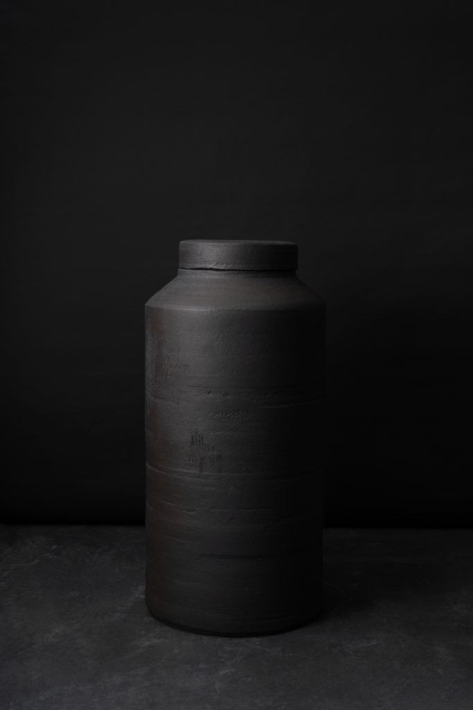 an image of a dark ceramic shaped like a cylinder