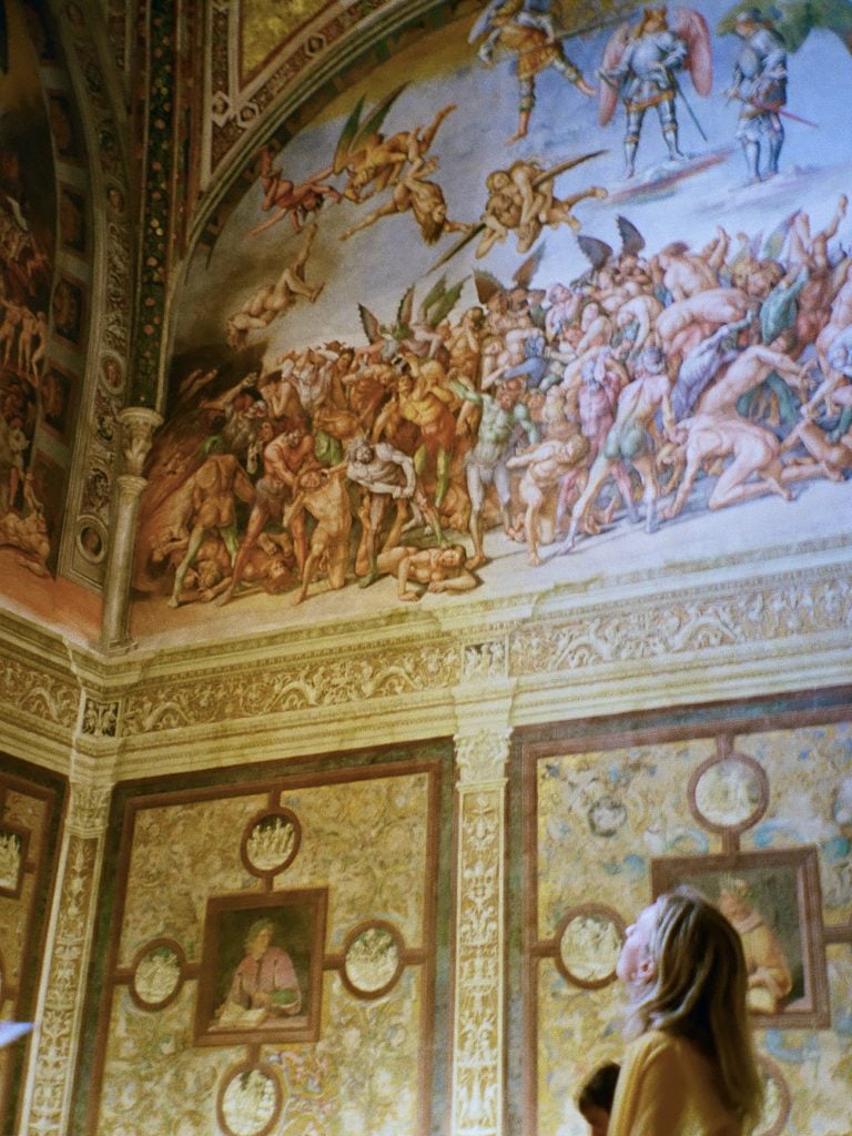 a woman looks at an ornate Italian ceiling fresco 