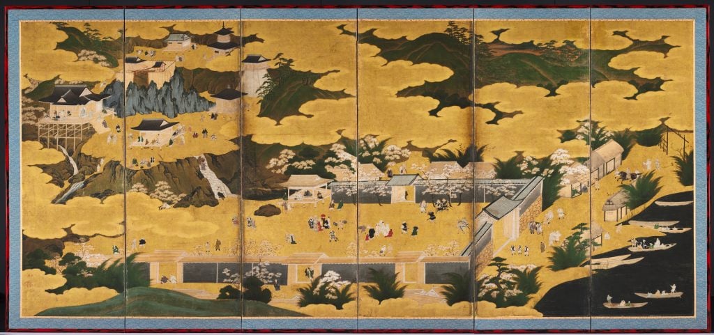 A traditional Japanese screen painting depicting a landscape with golden clouds, people, buildings, and boats along a river.