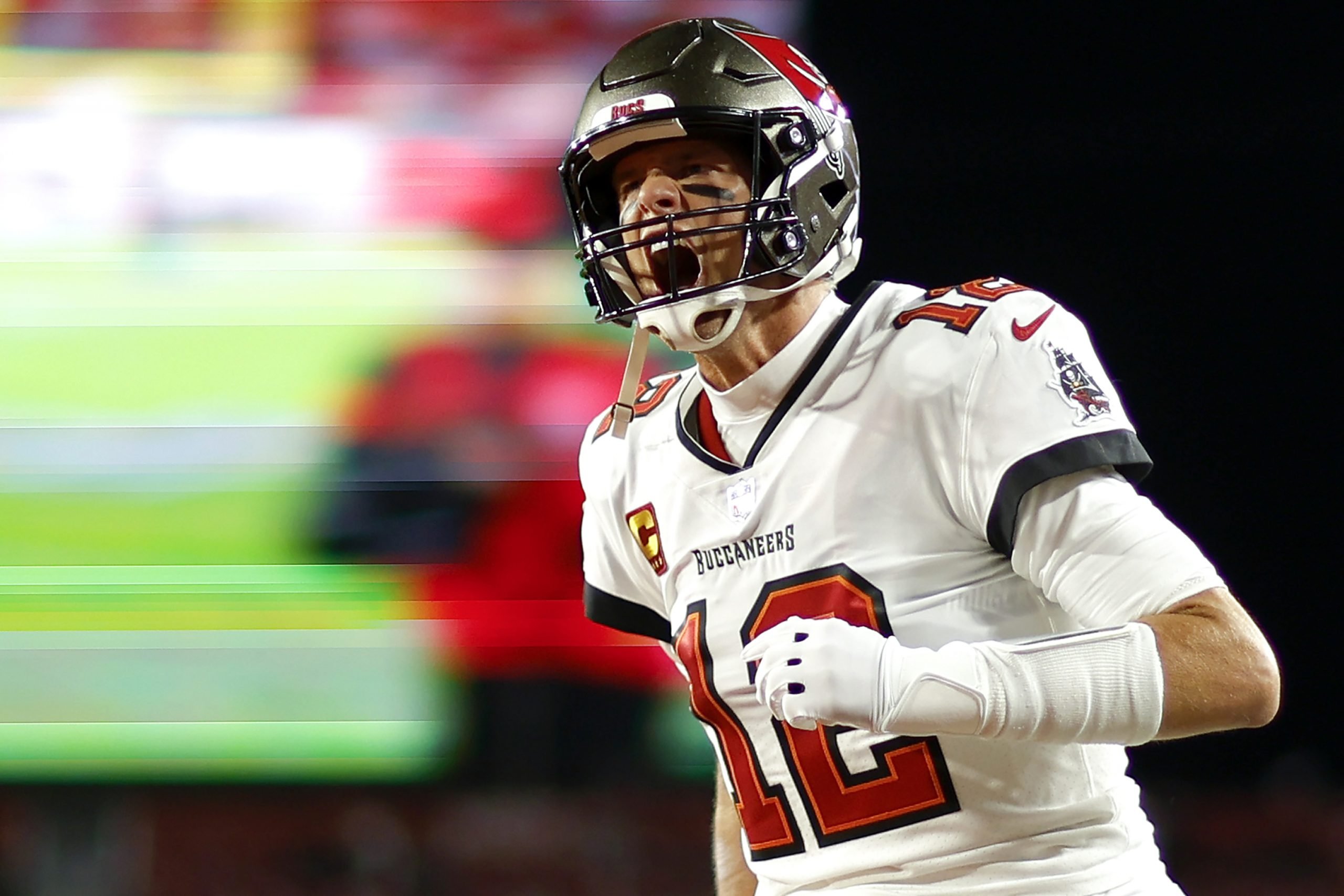 a football player in a white and red uniform is captured in focus with the background stadium blurred