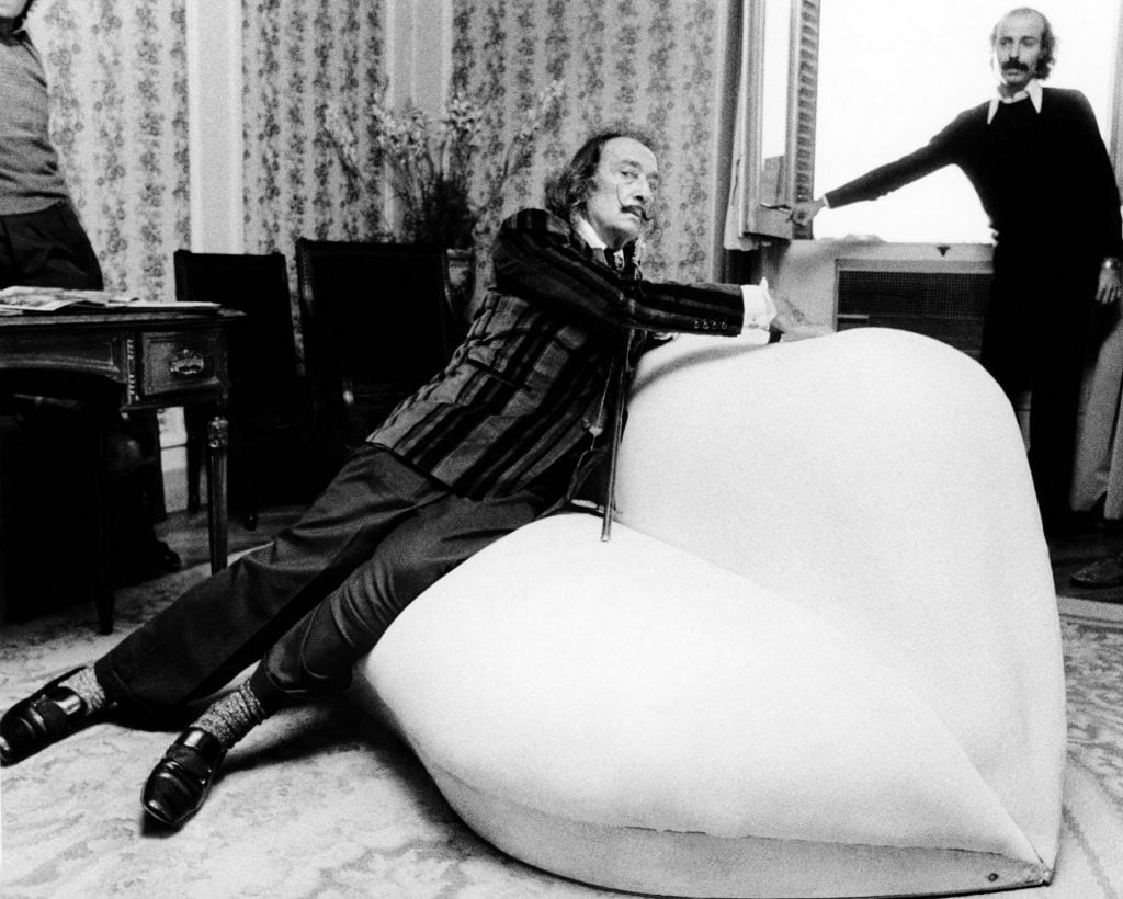 black and white photograph of Dali sitting on the Mae West sofa