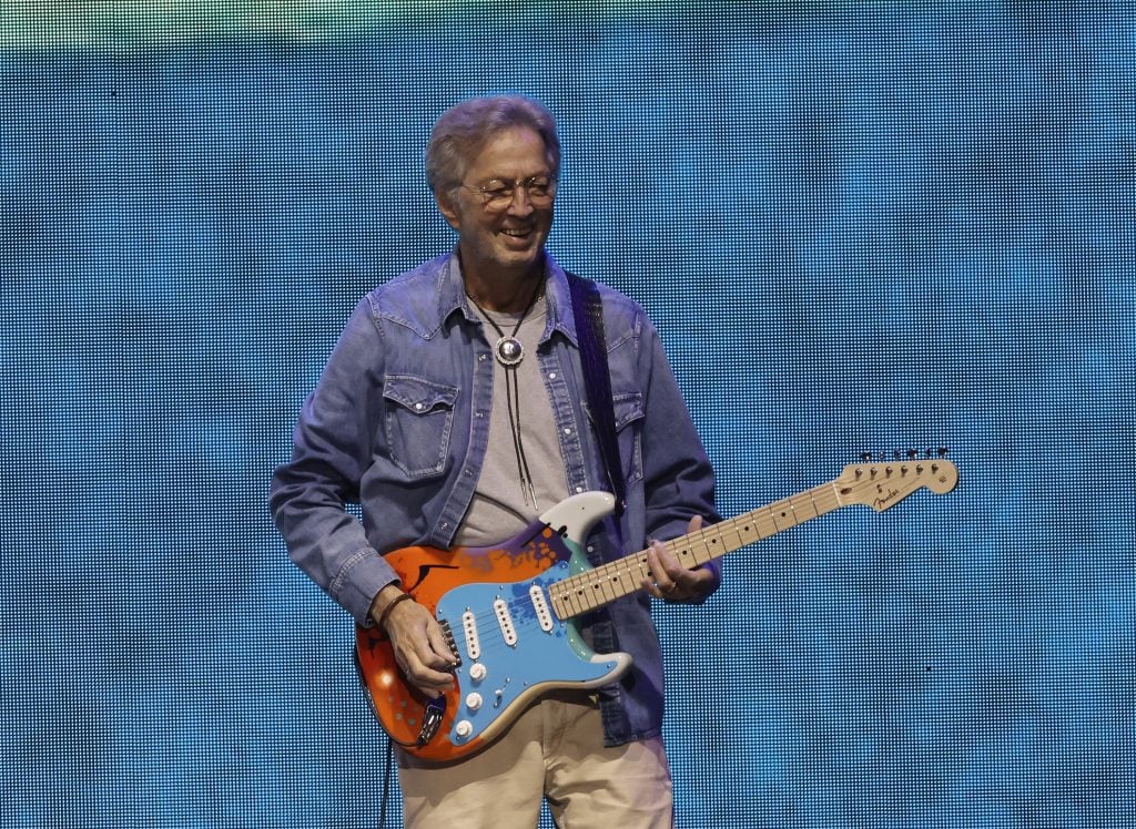 An older white man plays electric guitar