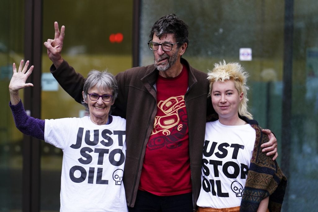 Three activists pose together, two wearing 