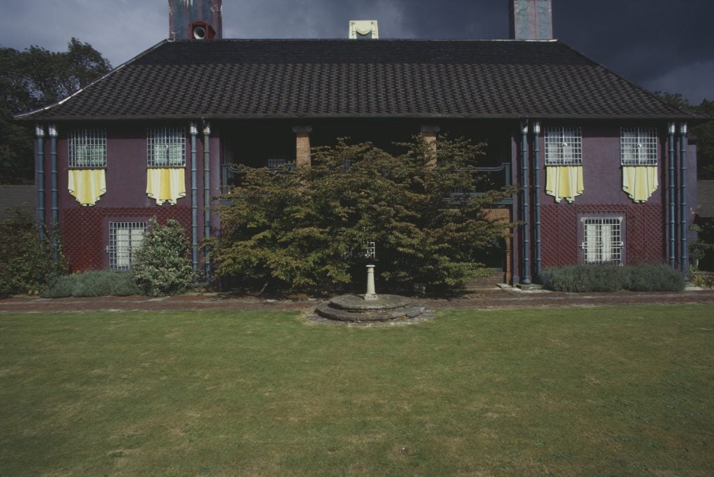 the exterior of a purple house and a green lawn