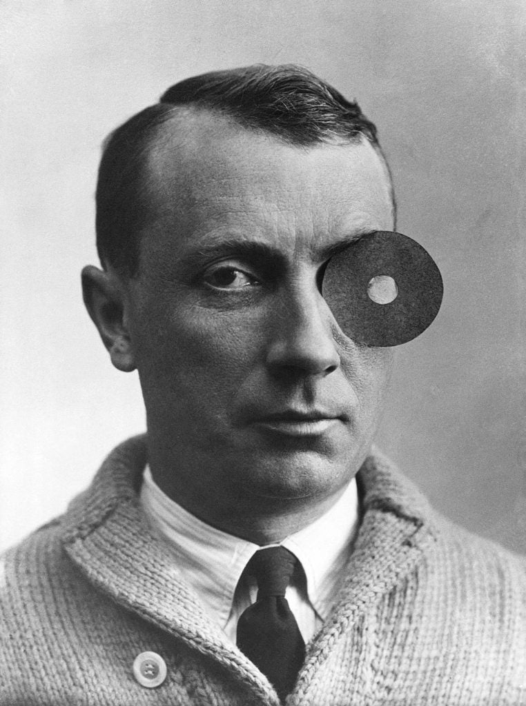 a black and white portrait of a man in a shirt, tie and jumper