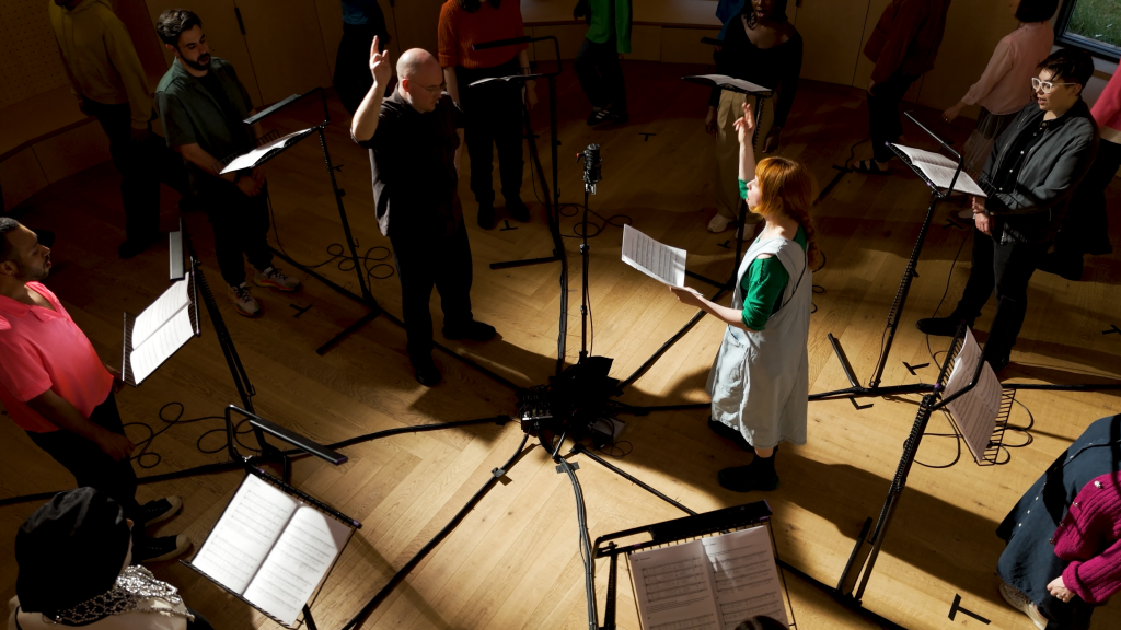 Holly Herndon and Mat Dryhurst conducting with a choir