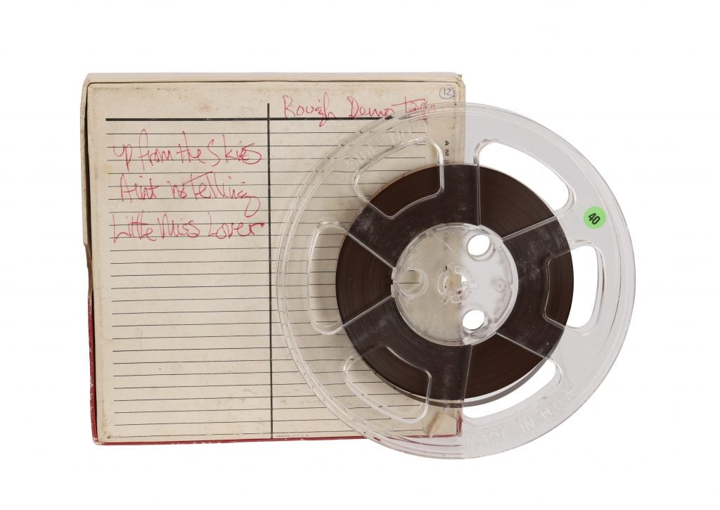 a tape disc on a white background alongside a book with words in red