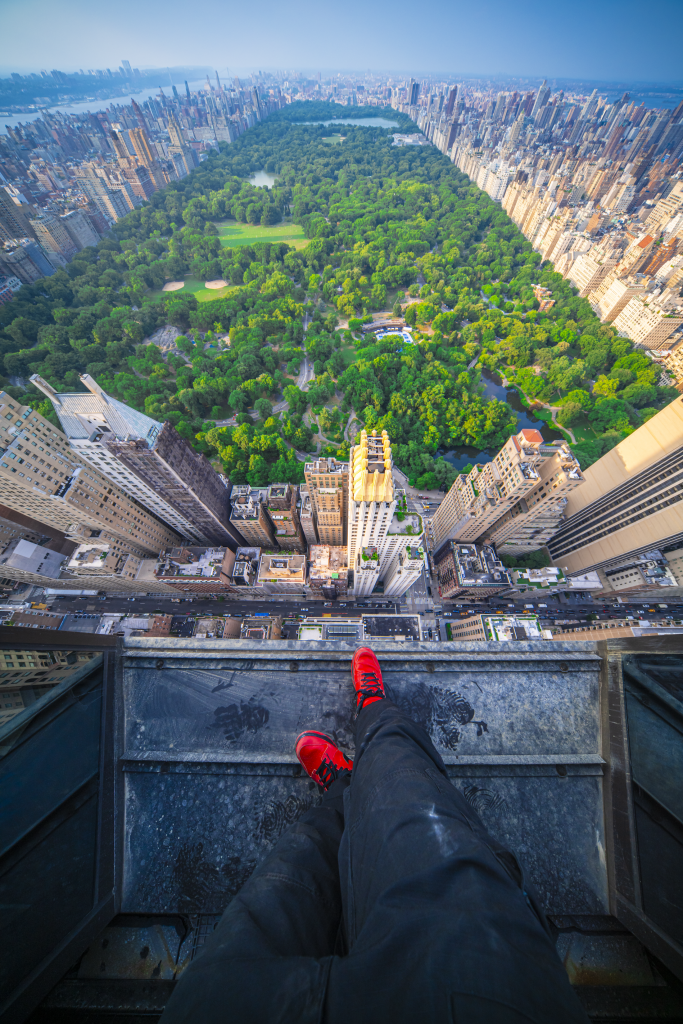 Isaac "Driftershoots" Wright's photograph the the top of Steinway Tower in New York. The image shows the photographer's feet and Central Park far below stretching out in the distance. 