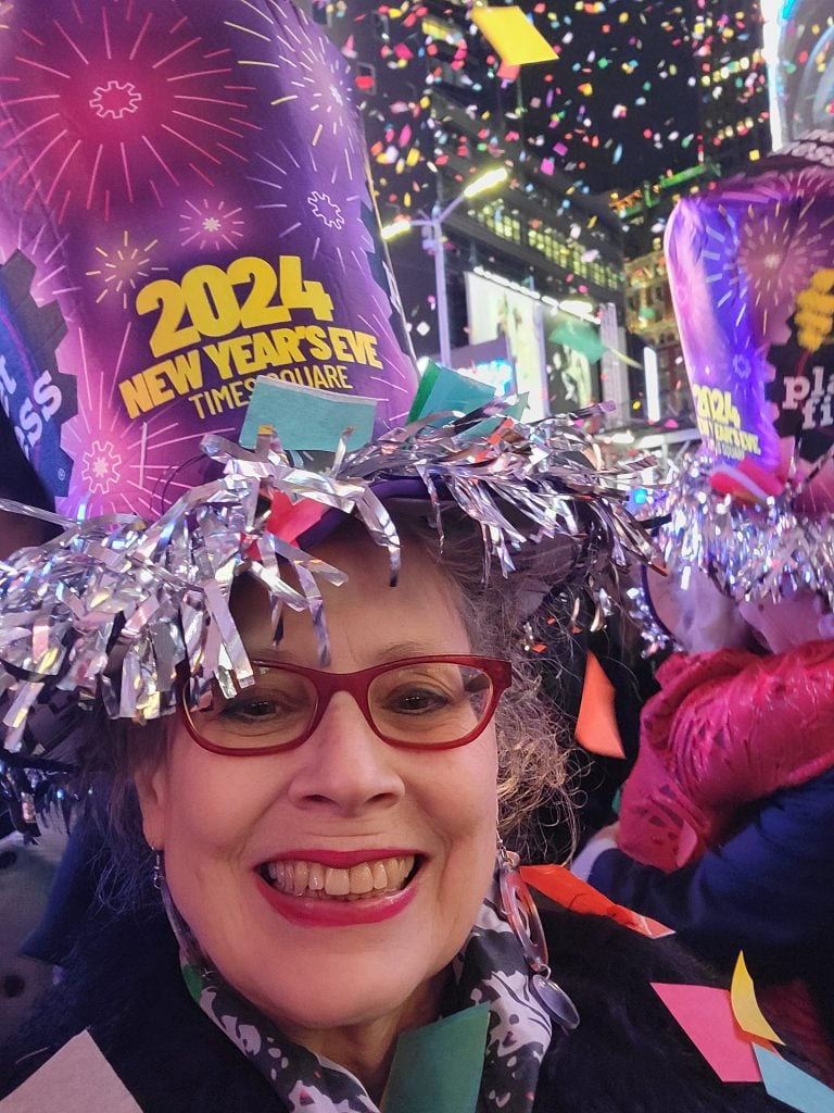 a woman in a celebratory NYE hat in Times Square