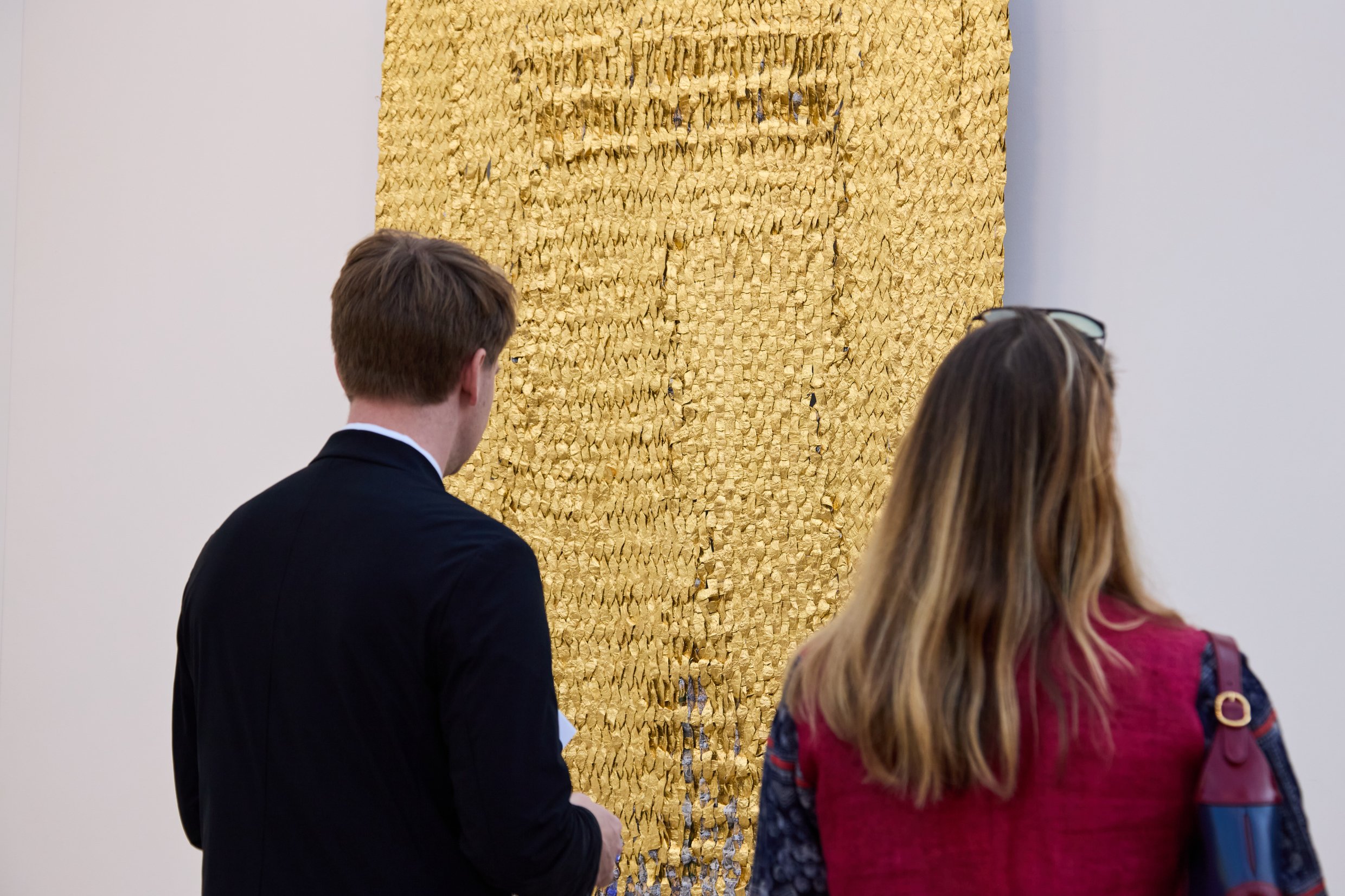 A shimmering gold work on the wall at Art Basel Paris