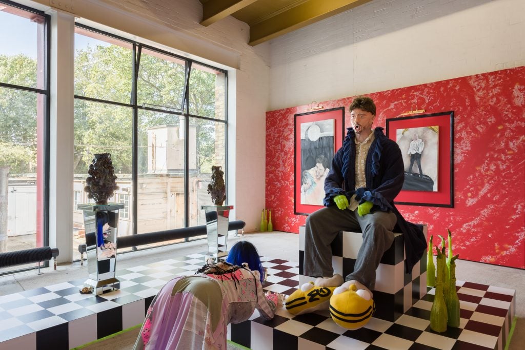 ceramic sculptures of two figures in garish colours in a gallery