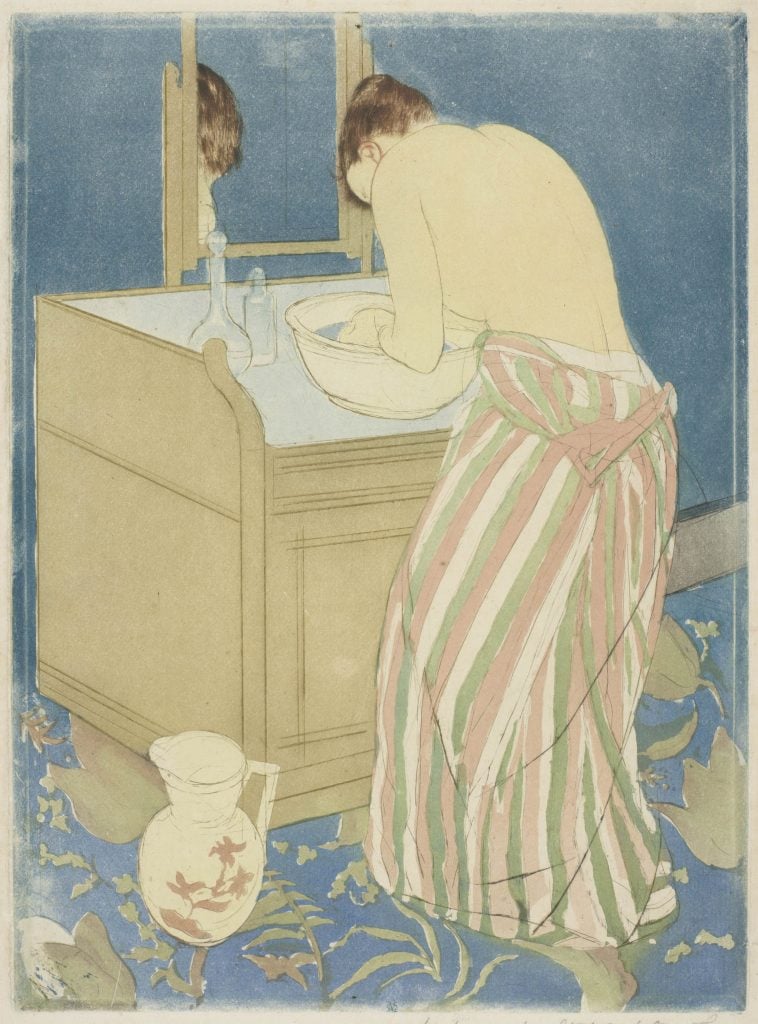 a half-dressed woman is seen from behind washing her hands in a bowl on a table