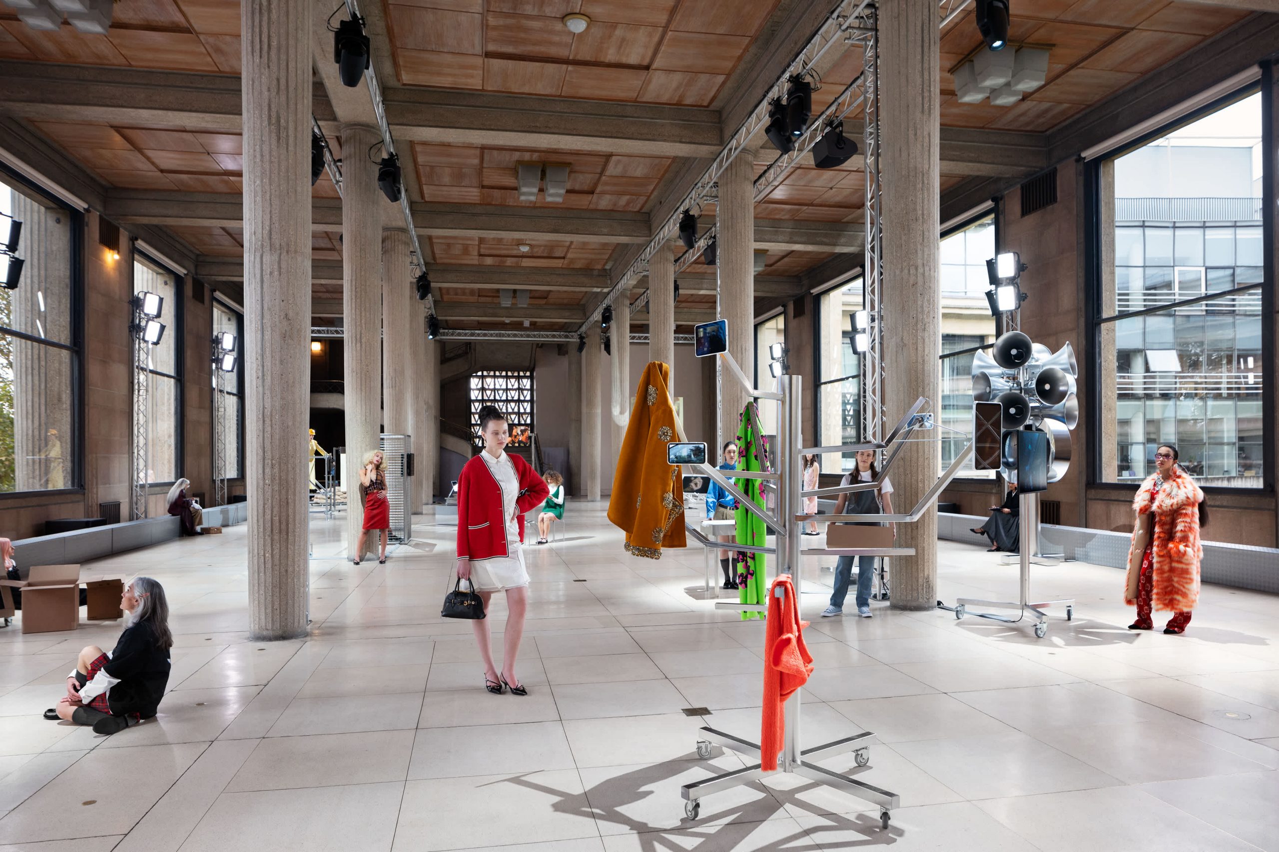 female models fill a grand hall with large pillars