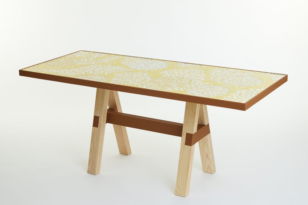 a yellow table has a mosaic top