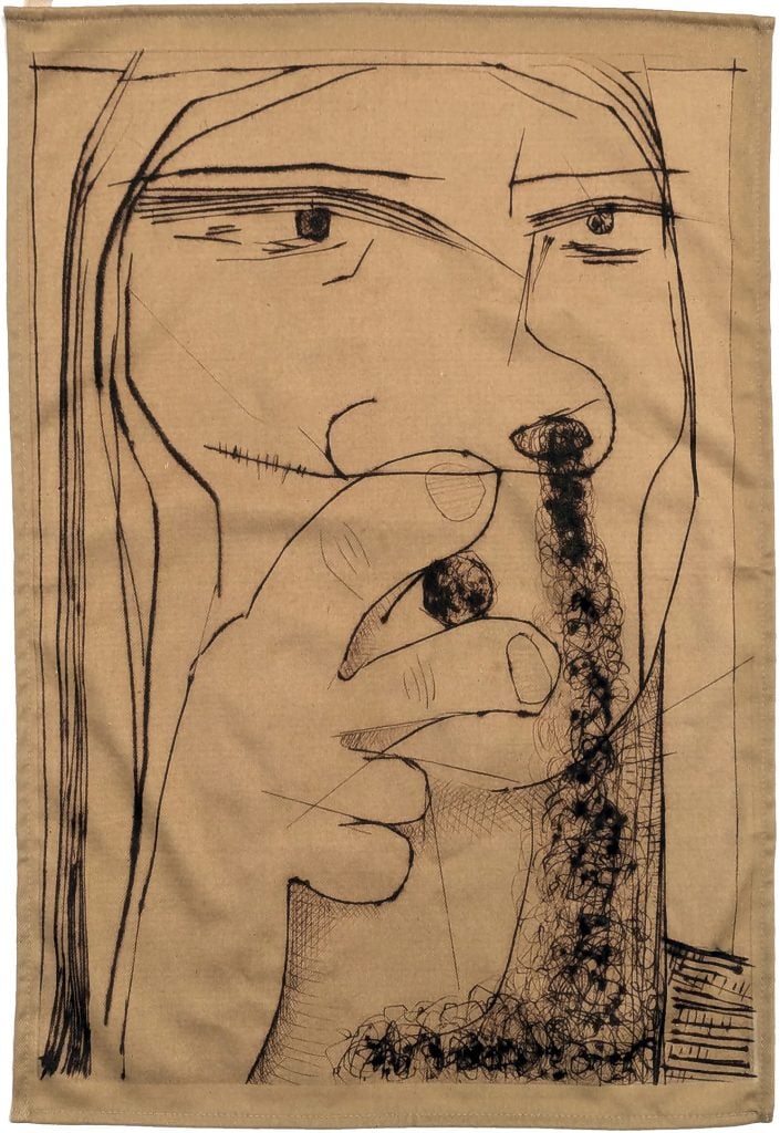 a scrap of fabric with a black etched drawing very close-up of a seemingly female figure smoking a cigarette or cigar with the smoke coming out of their nostril