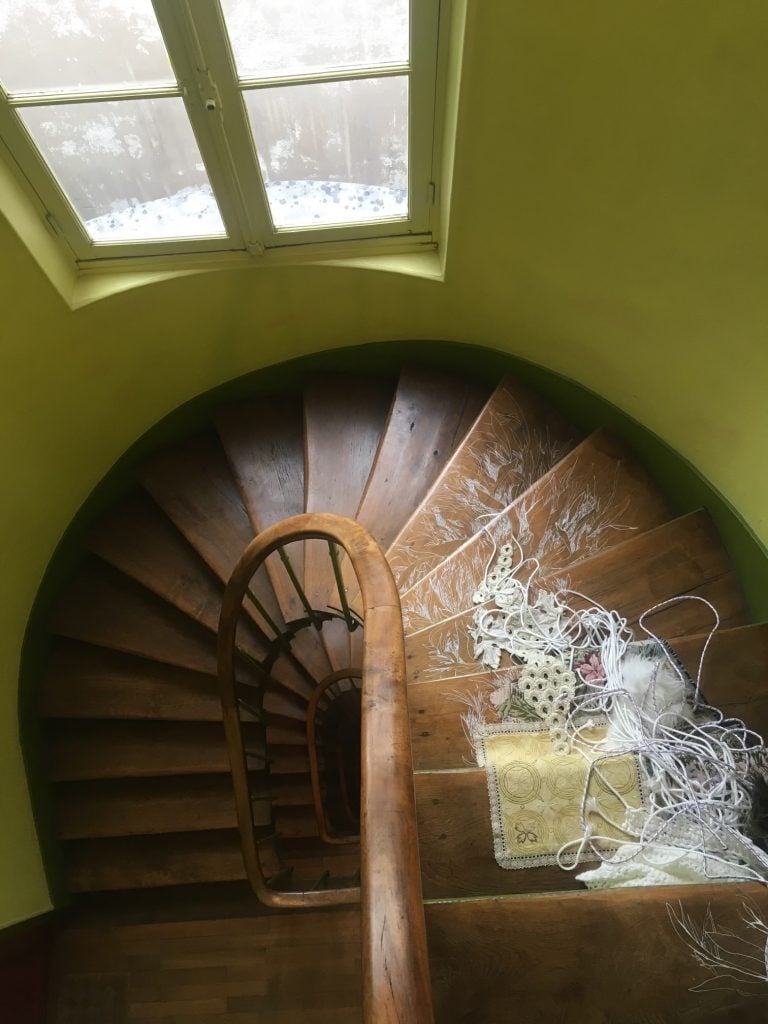 A fiber installation by Suchitra Mattai spilling out of her small Paris apartment and down the spiral staircase. 