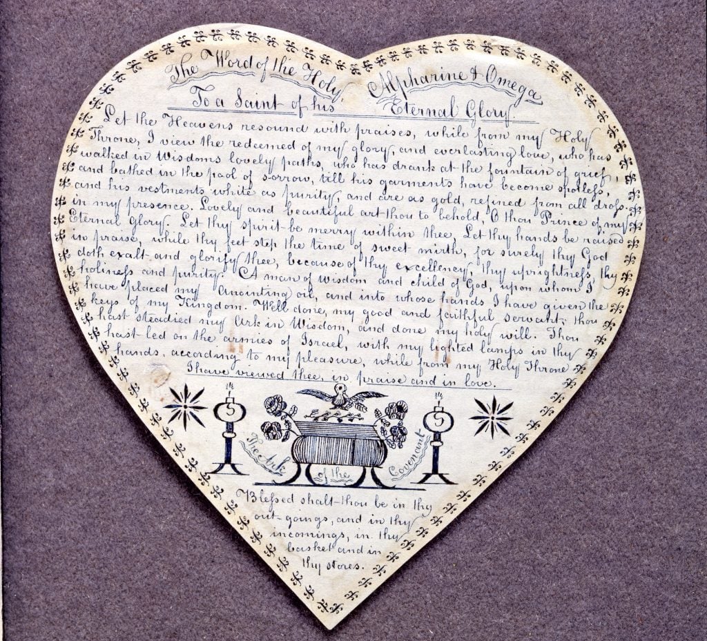 an image of a shaker drawing on a heart-shaped cutout with symbols and writing