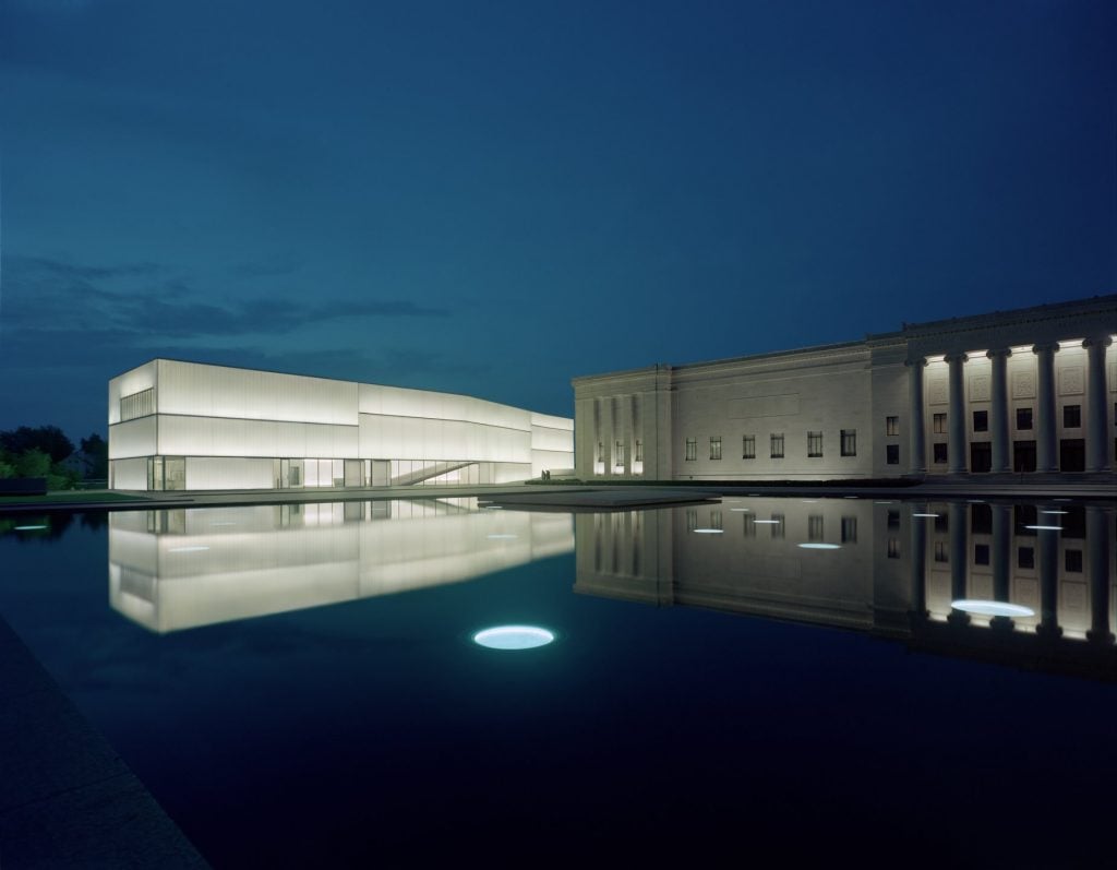 Two abutting rectangular buildings glowing in the night