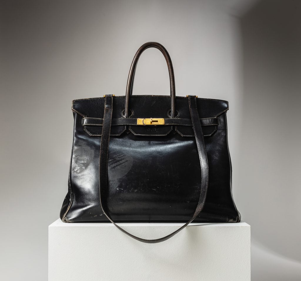 A black Birkin bag on a pedestal at Sotheby's Paris