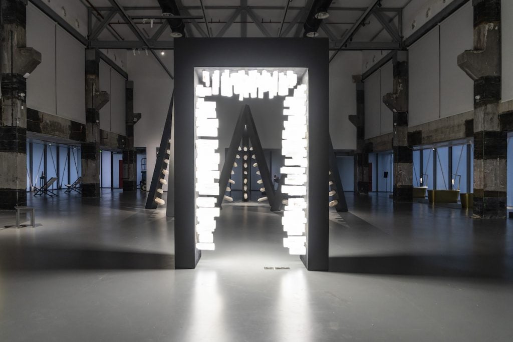 illuminated crystals fill and empty door frame in a dimly lit gallery