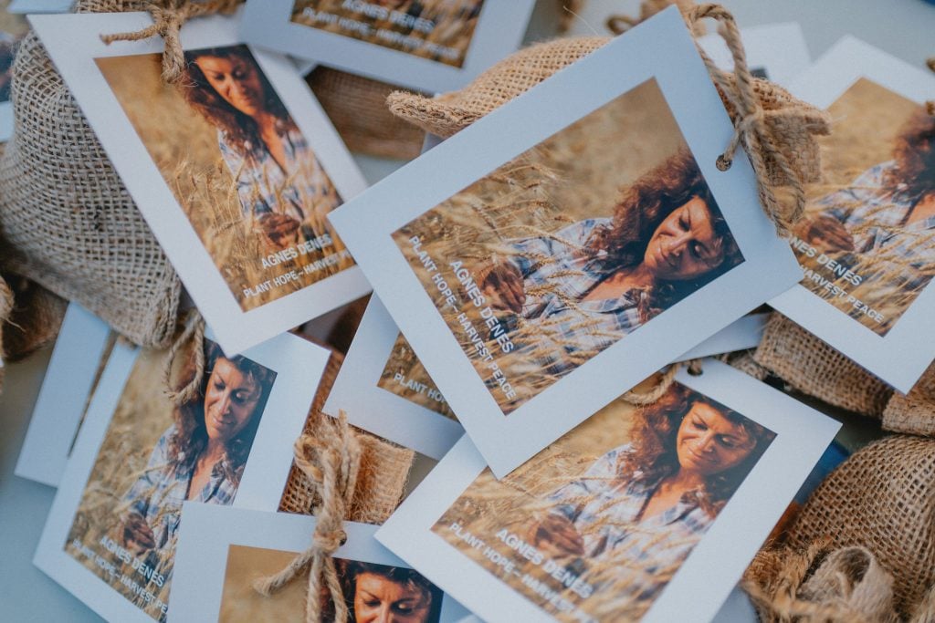 A pile of seed packets with a vintage photo of artist Agnes Denes on the front.