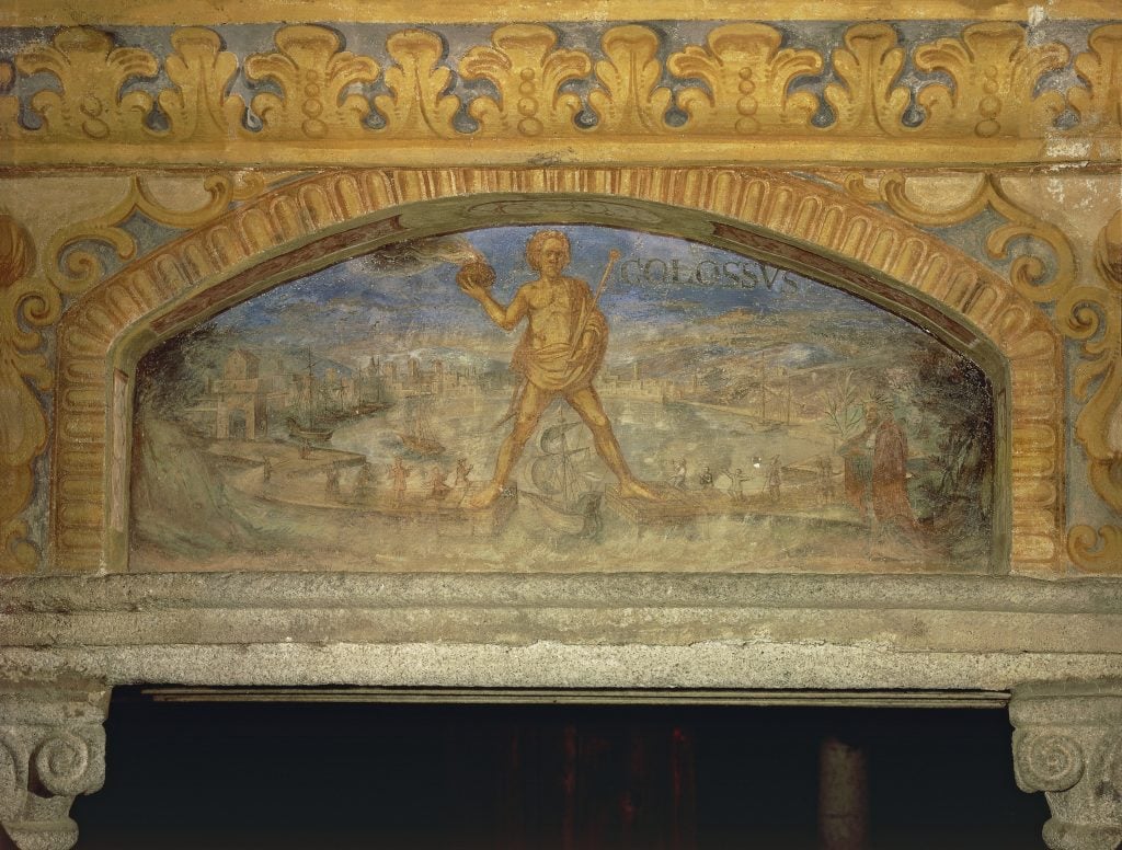 An ancient fresco painted with a large statue astride two ports