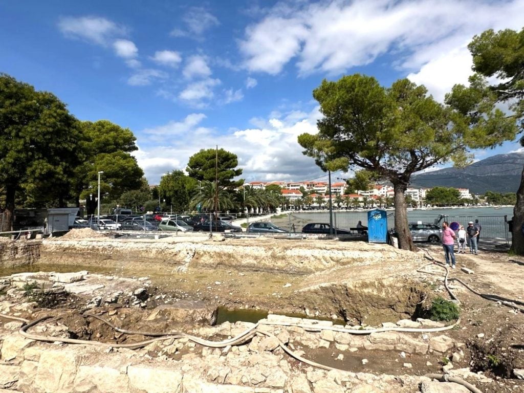 view of dirt, trees, water and seaside town