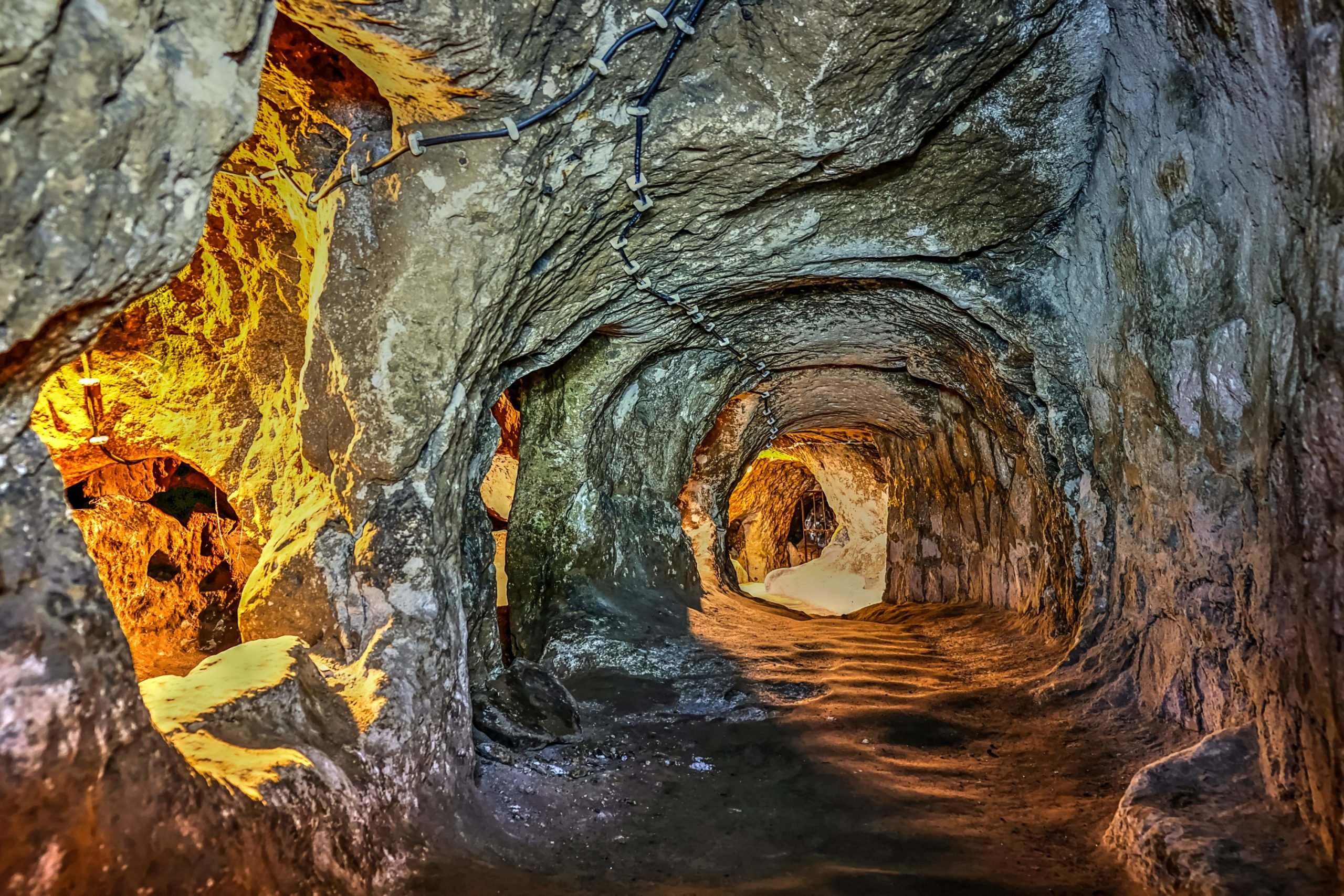 Inside a cave with a path leading to other rock chambers