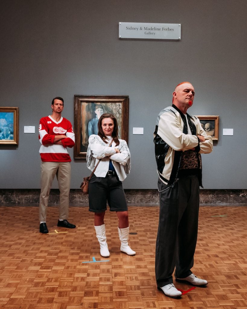 "Darren McCarty's Day Off" filming at the Detroit Institute of Arts on September 16, 2024. Three adults mimic the scene in Ferris Bueller's Day Off where the three main characters stare, arms folded, at artworks in a gallery. Danny DeKeyser, Daniella Bruce, and Darren McCarty are in front of Paul Cézanne’s Three Skulls (ca. 1898) and Madame Cézanne (1886–87). 