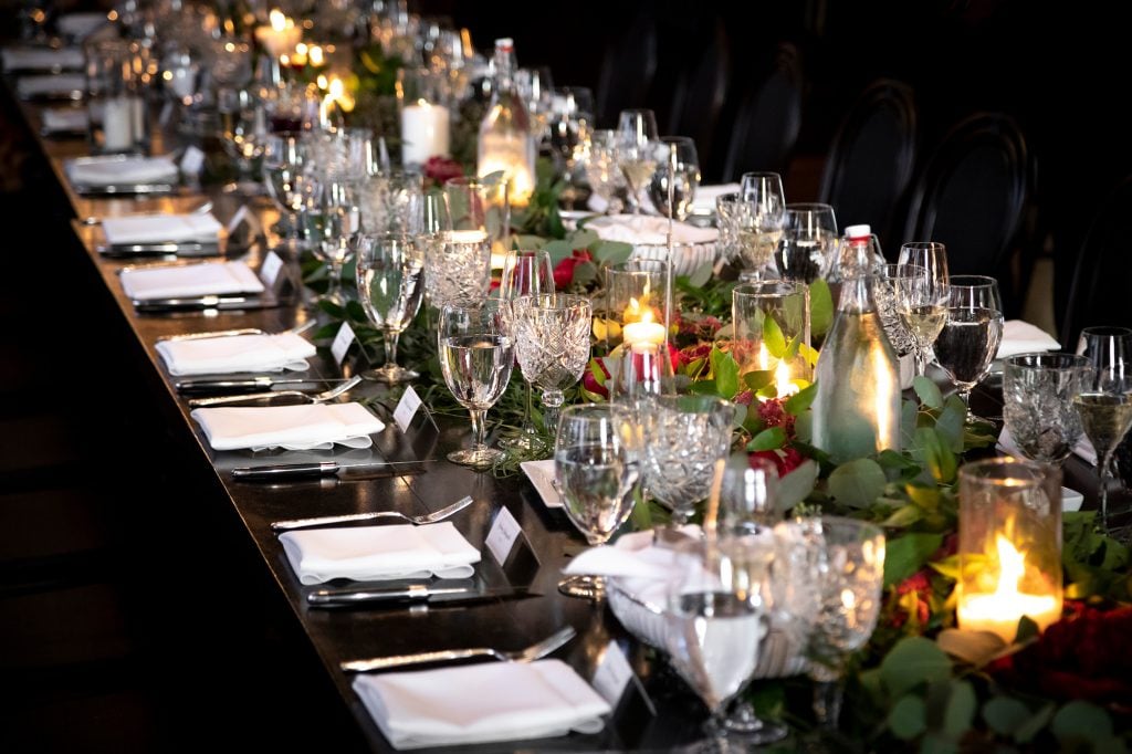 View down an ornate wedding banquet table, with crystal place settings and floral centerpieces