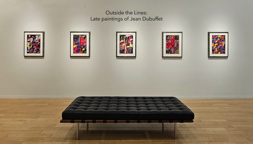 Four small-scale abstract paintings by Jean Dubuffet installed on a wall behind a leather settee, with the title of the exhibition above the paintings on the wall in Vinyl, shown at Jonathan Novak Contemporary Art Gallery.