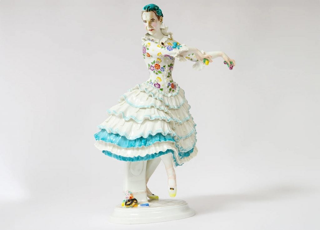 A porcelain figurine shows a man in a fine dress, dancing