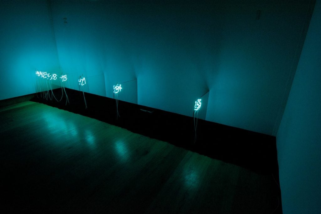 A series of neon numbers in a darkened room by Arte Povera artist Mario Merz.