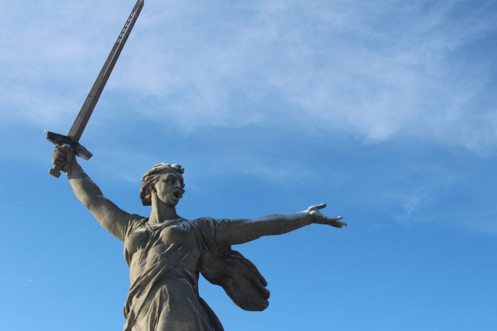 A statue of a woman holding a sword in one hand, her other arm outstretched