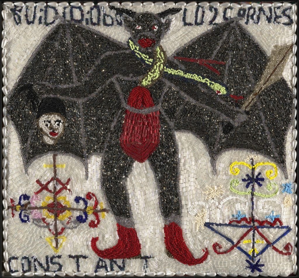 A beaded flag depicting a bat-man hybrid holding a sword and a disembodied head