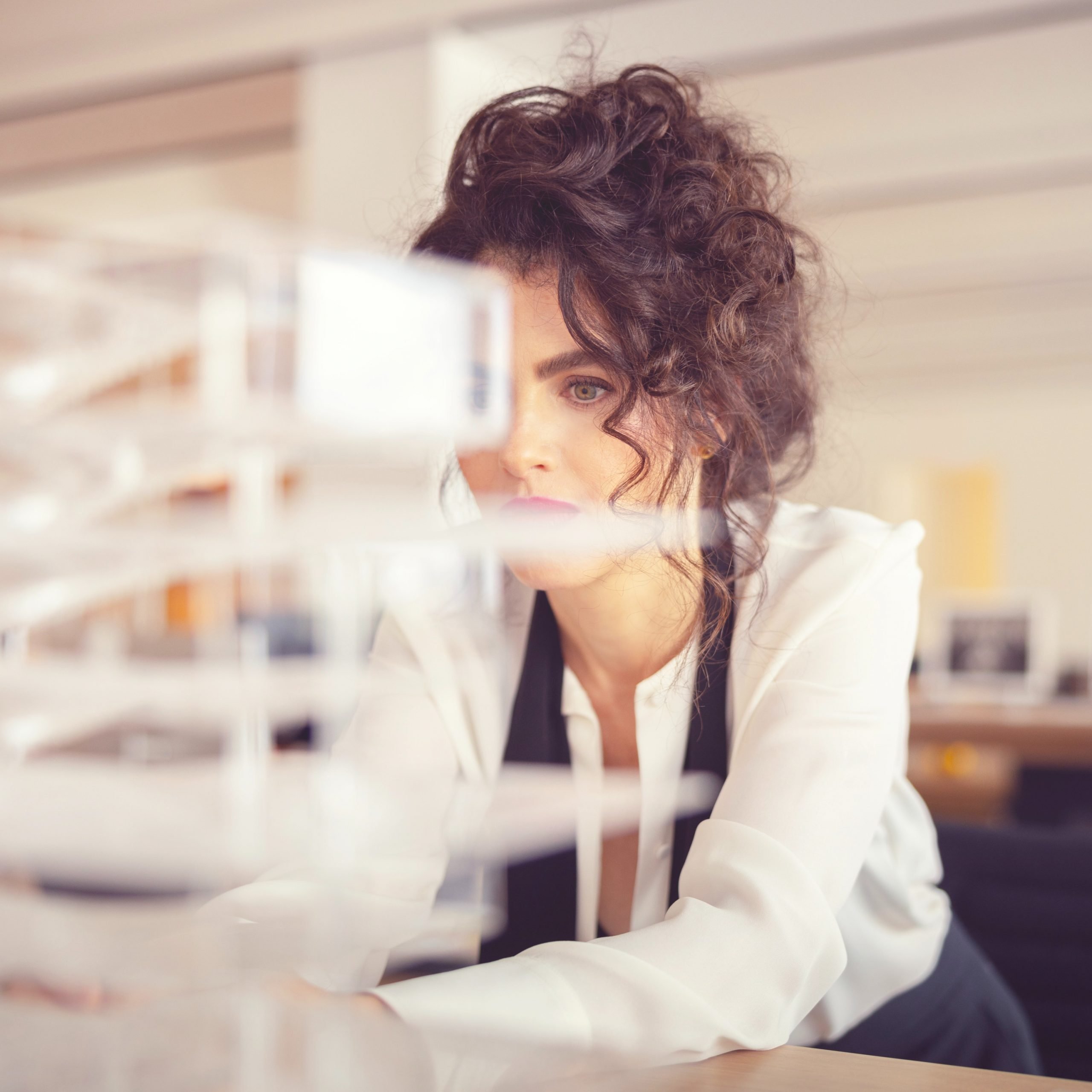 Neri Oxman peering at a model in a lab