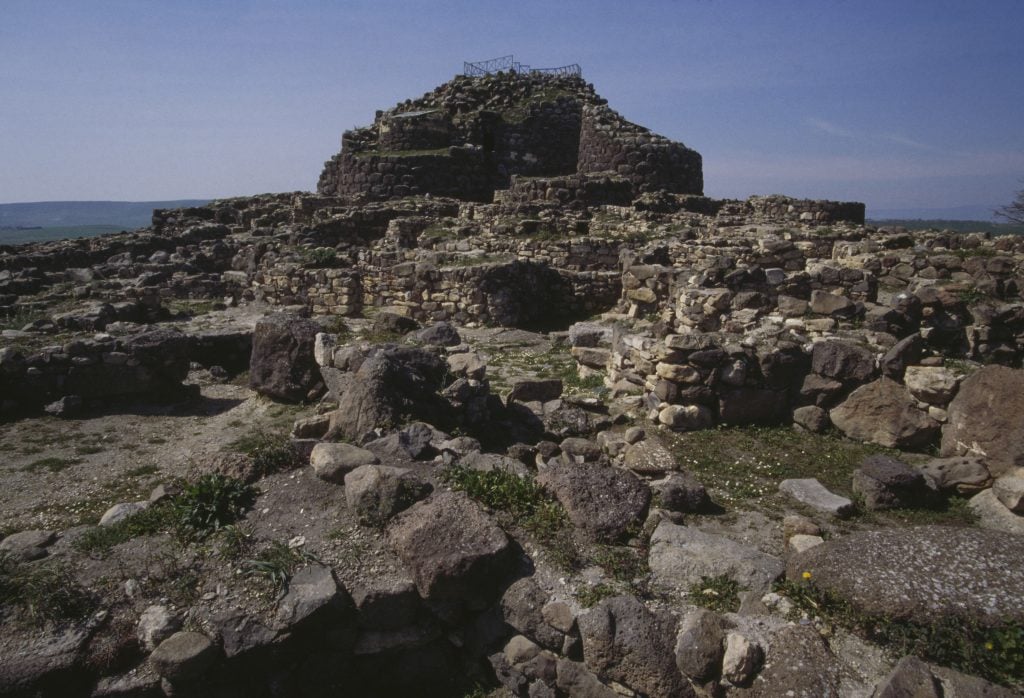 a large mound of grey brown rocks assembled into an old decaying tower structure